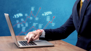 Satıcı dizüstü bilgisayarla grafikle çalışıyor.