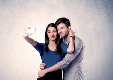 Mutlu çift temiz duvarlı selfie çekiyor.