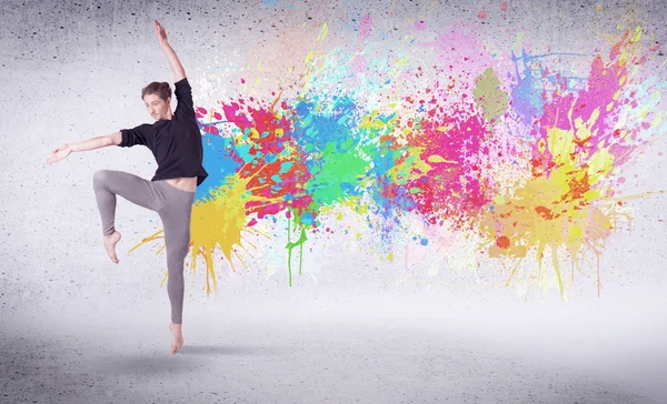 Moderne street danser springen met kleurrijke verf spatten — Stockfoto