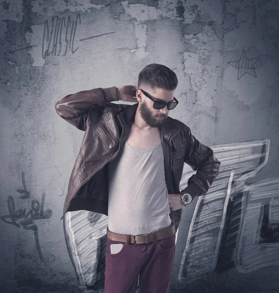 Fashion model standing at graffiti wall — Stock Photo, Image