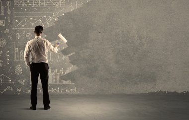 Satış elemanı duvardaki tabloların üstünü boyuyor.