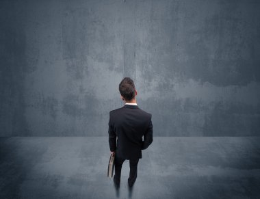 Şehir duvarının önünde duran iş adamı