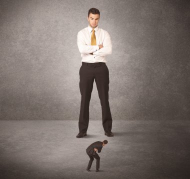 Büyük iş adamı küçük işçilere bakıyor.