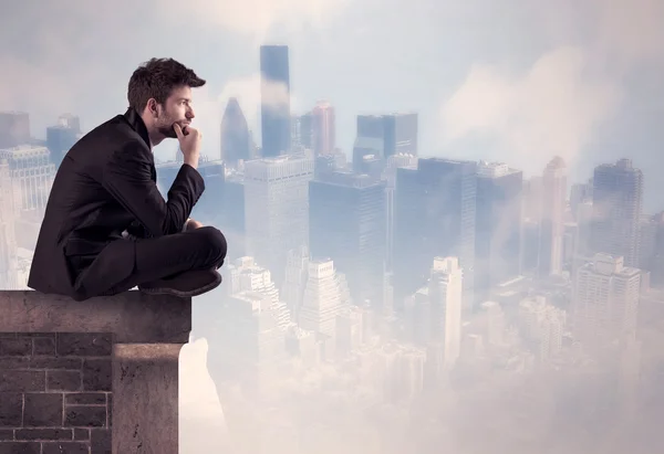 Sales person sitting on top of a tall building — Stock Photo, Image