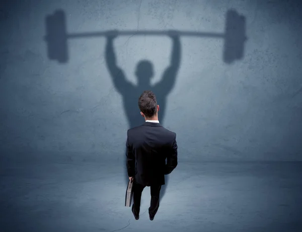 Businessman with weight lifting shadow — Stock Photo, Image