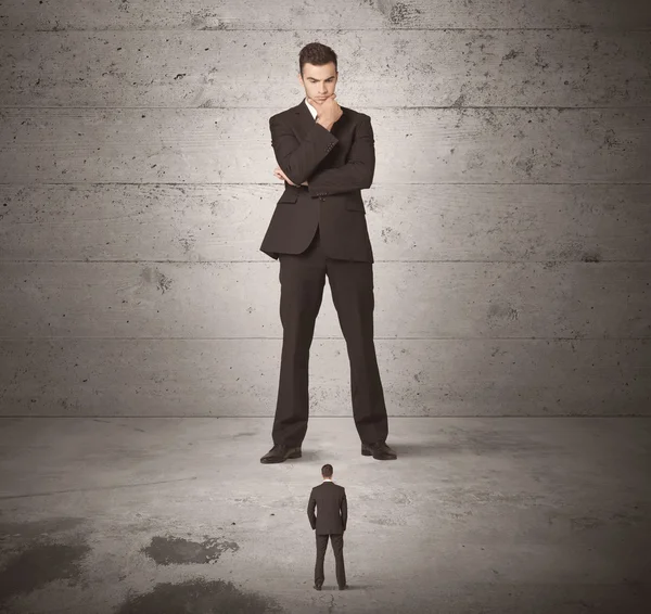 Huge business guy looking at small coworker — Stock Photo, Image