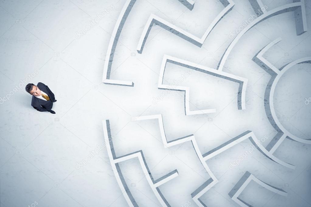 Business man looking at circular maze with nowhere to go