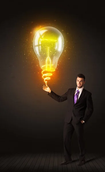 Бизнесмен с лампочкой идеи — стоковое фото