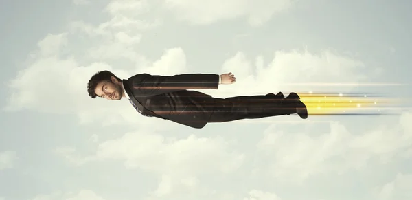 Happy business man flying fast on the sky between clouds — Stock Photo, Image