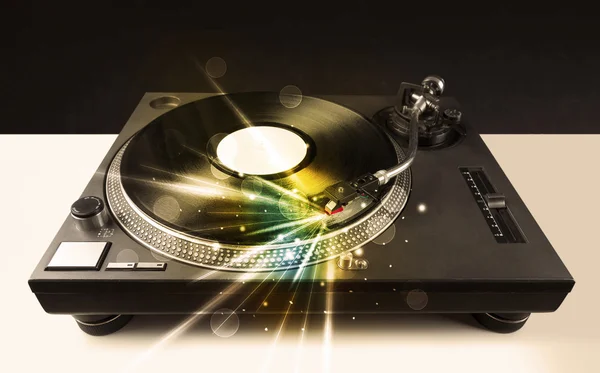 Music player playing vinyl with glow lines coming from the need — стоковое фото