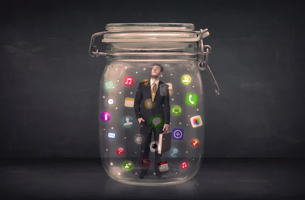 Empresário capturado em um frasco de vidro com ícones coloridos app con — Fotografia de Stock