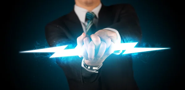 Business man holding glowing lightning bolt in his hands — Stock Photo, Image