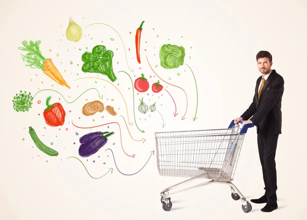 Businessman with shopping cart with vegetables — Stock Photo, Image