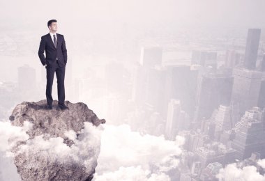 Kayanın üzerinde duran kazanan iş kişi