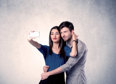Mutlu çift temiz duvarlı selfie çekiyor.