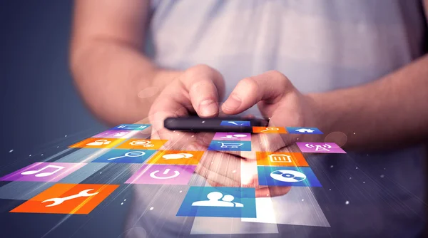 Hombre sosteniendo el teléfono inteligente con iconos de aplicación de colores —  Fotos de Stock