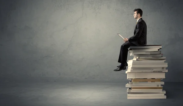 Student sitting on pile of books — Stock Photo, Image