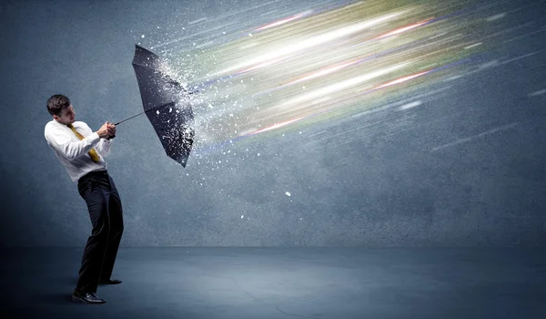 Uomo d'affari difendere fasci di luce con concetto di ombrello — Foto Stock