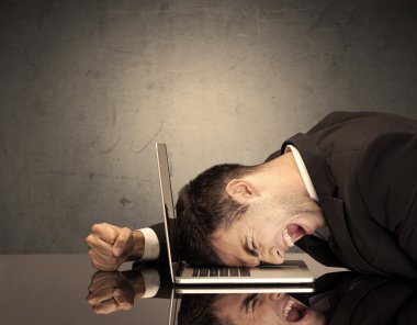 Sinirli iş adamının kafası klavyede