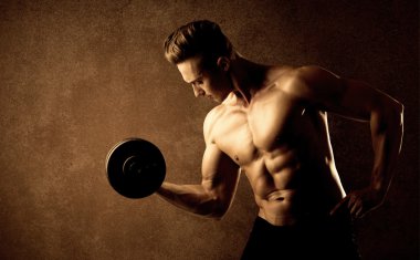 Kas formundaki vücut geliştirici sporcu ağırlık kaldırıyor 