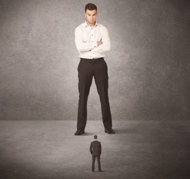 Büyük iş adamı küçük işçilere bakıyor.