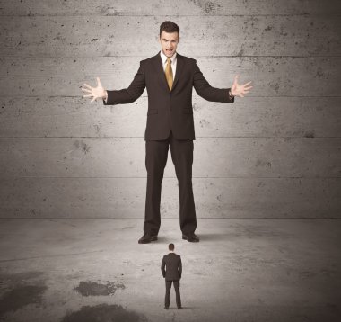 Büyük bir iş adamı küçük bir iş arkadaşına bakıyor.