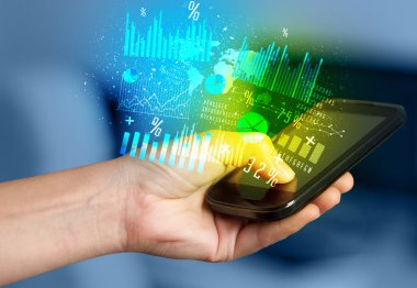 İş diyagramları ile Smartphone tutan el