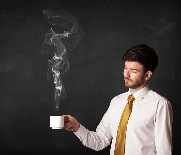 Businessman holding a white steamy cup — Stock Photo, Image