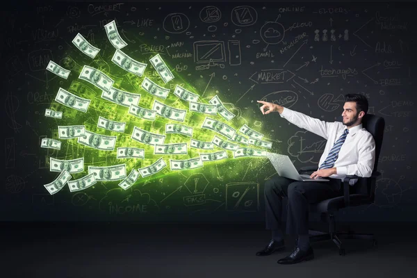 Businessman sitting in chair holding laptop with dollar bills co — Stock Photo, Image