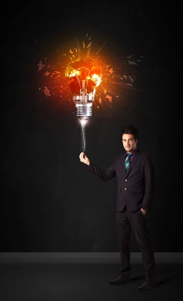Бизнесмен со взрывной лампочкой — стоковое фото