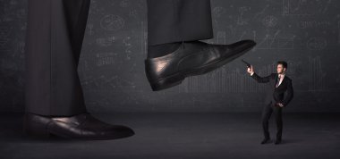 Büyük bacak küçük bir işadamı konseptine basıyor.