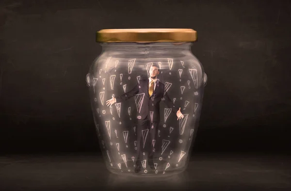 Business man trapped in jar with exclamation marks concept — Stock Photo, Image