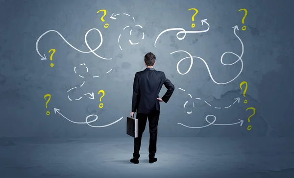 Unsure businessman with question marks — Stock Photo, Image