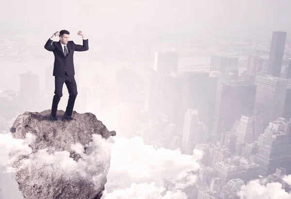 Победитель деловой человек, стоящий на скале — стоковое фото