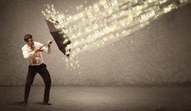 İş adamı dolar yağmuruna karşı şemsiye tutuyor