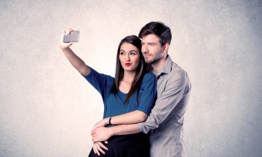 Mutlu çift temiz duvarlı selfie çekiyor.