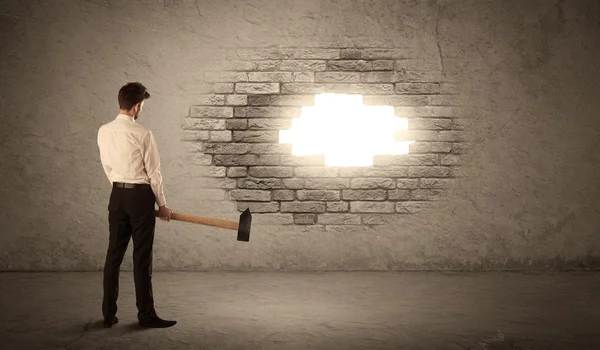 Business man hitting brick wall with hammer and opening a hole — Stock Photo, Image