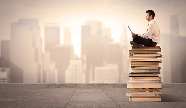 Man boven de stad zittend op boeken — Stockfoto