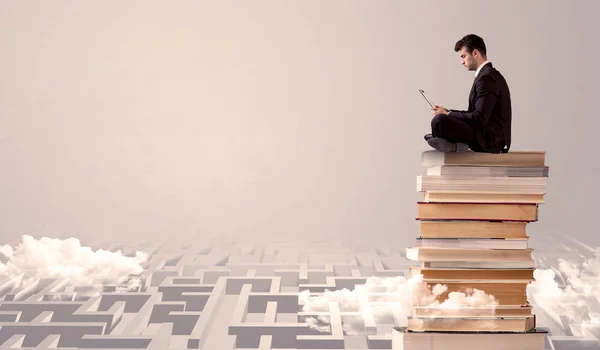 Hombre con tableta sentado en los libros — Foto de Stock