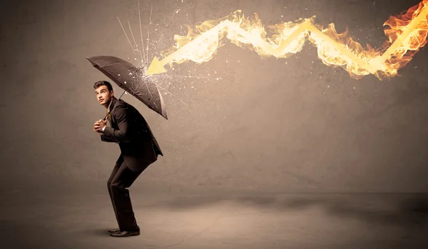 Business man defending himself from a fire arrow with an umbrell — Stock Photo, Image