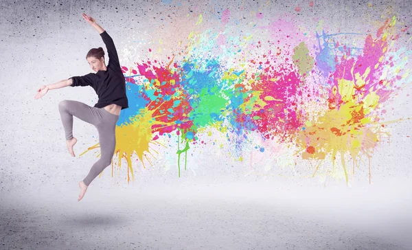Nowoczesny tancerz uliczny skacze z kolorowymi plamami farby — Zdjęcie stockowe