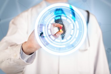 Erkek doktor elinde parlak halkaları olan bir hap tutuyor.