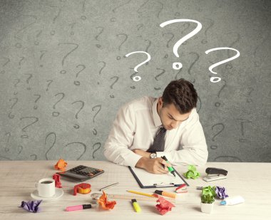 İş adamı soru işaretiyle masada.