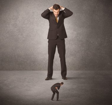 Büyük iş adamı küçük işçilere bakıyor.