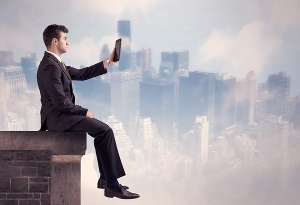 Sales person sitting on top of a tall building — Stock Photo, Image