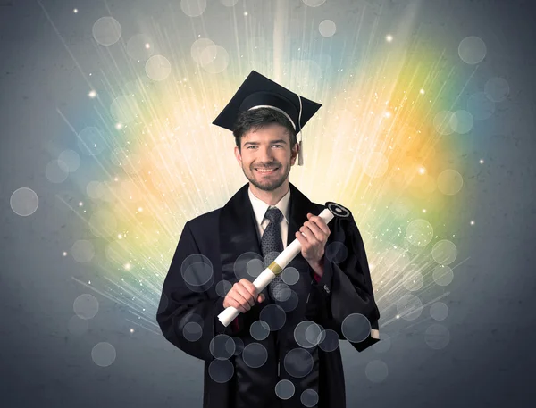 Feliz graduado con luces bokeg de colores en el fondo — Foto de Stock