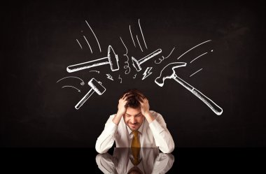Depresyondaki işadamı çekiç izlerinin altında oturuyor
