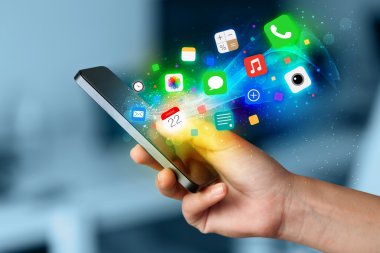 Renkli uygulama simgeleriyle el ele tutuşan akıllı telefon
