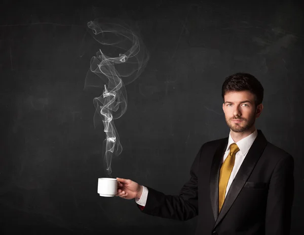 Affärsman som håller en vit ångande kopp — Stockfoto