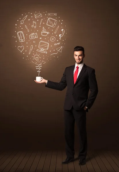 Businessman holding a white cup with social media icons — Stock Photo, Image